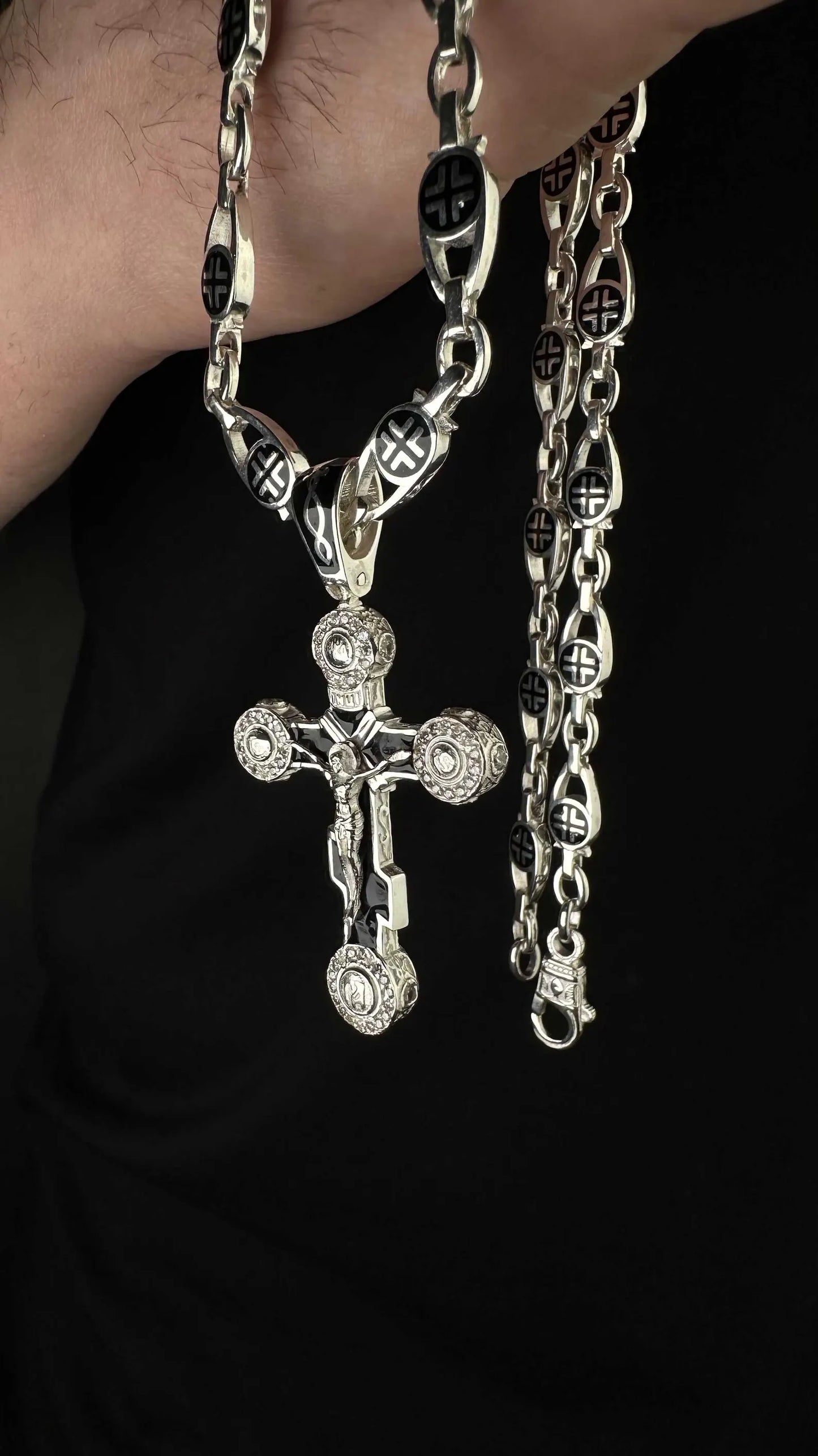 Close-up of men's silver chain with crosses