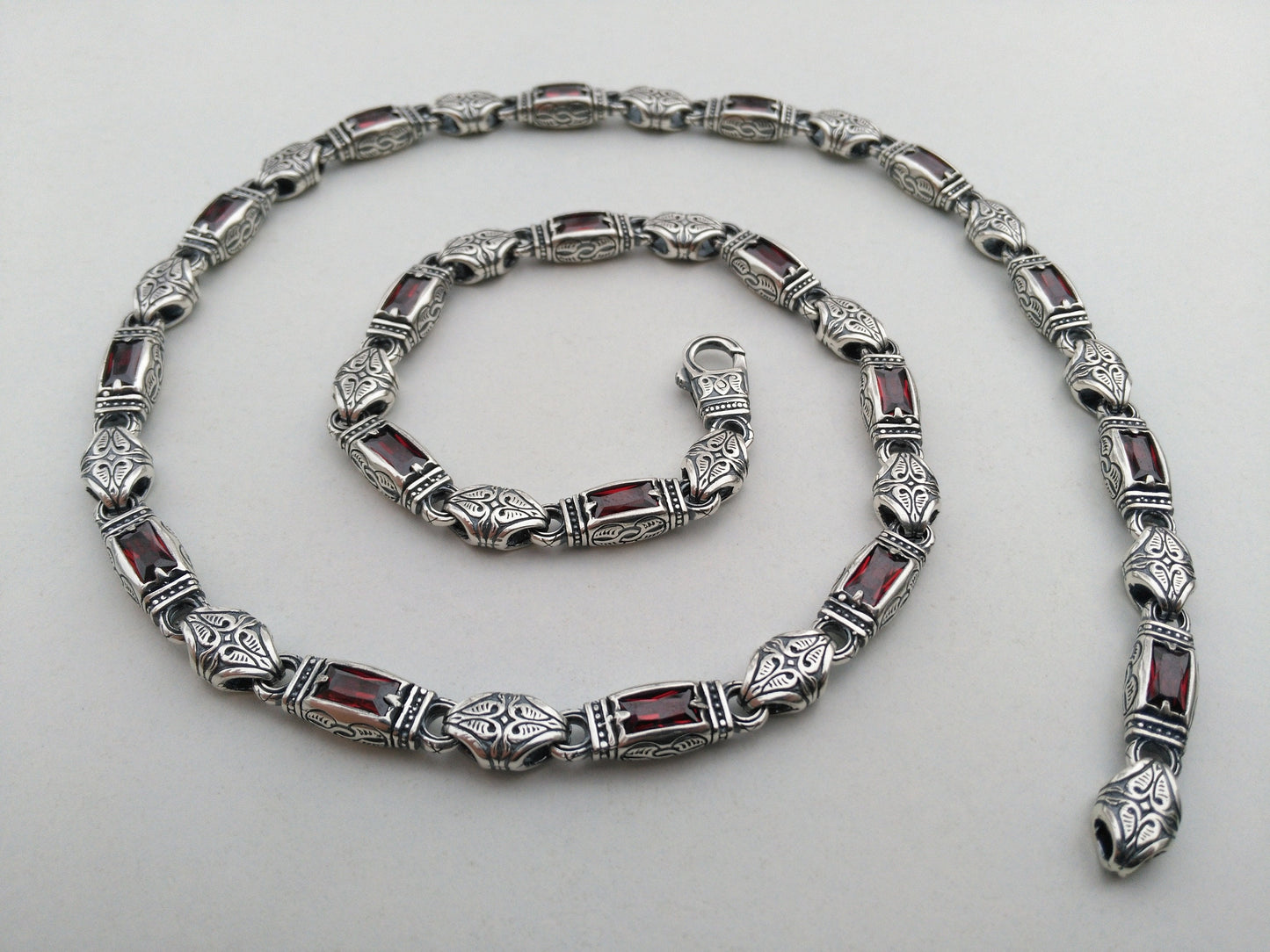 silver necklace with red stones and hand engraving