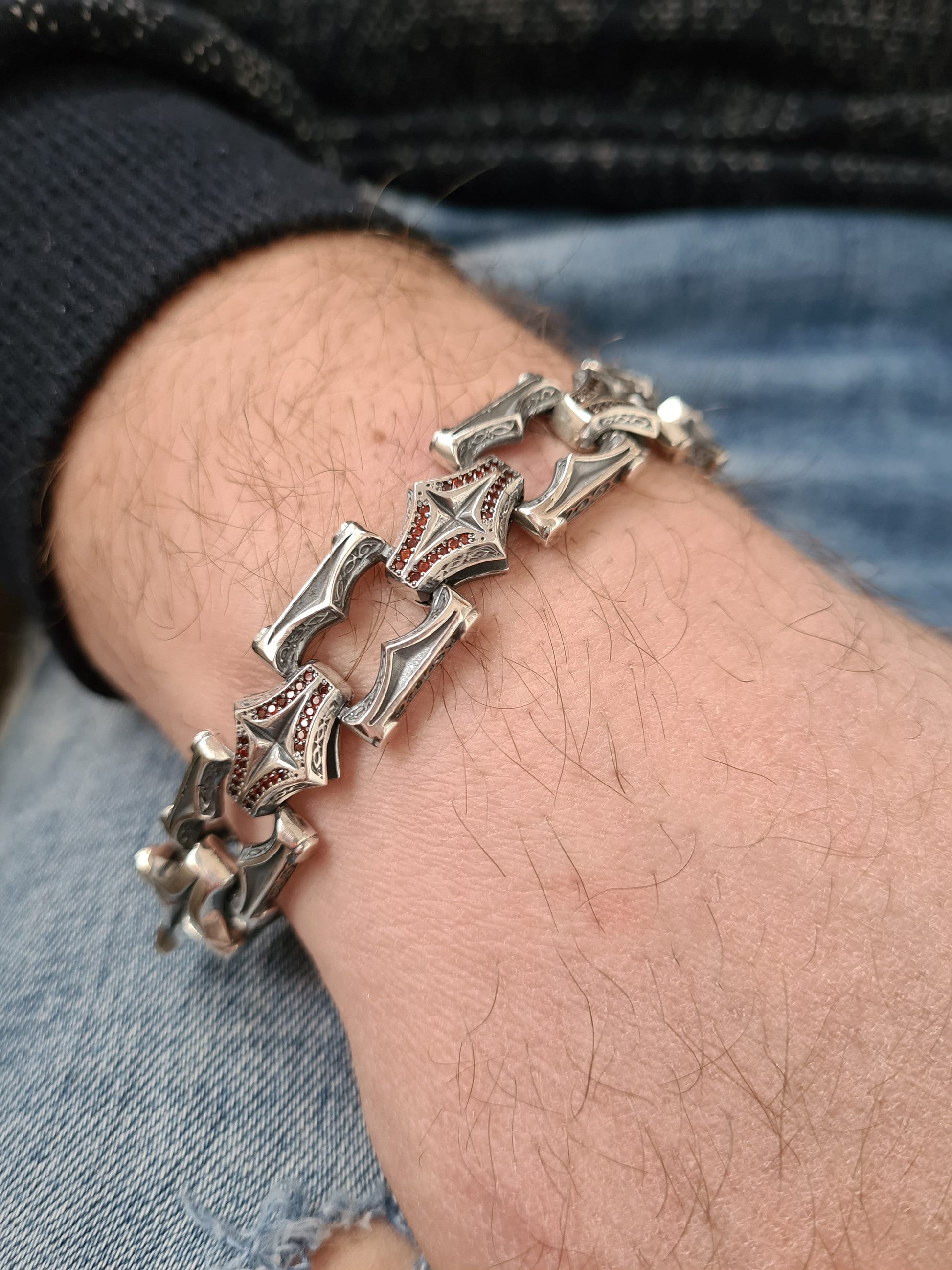 Dark red garnet stones in gothic silver bracelet worn on male wrist