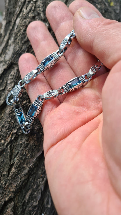 Sterling silver men's bracelet with blue topaz and Ukrainian trident symbol. Patriotic jewelry combining natural gemstones with national heritage