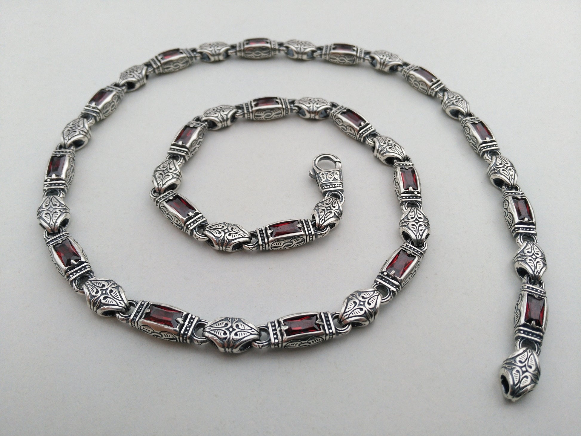 silver necklace with red stones and hand engraving