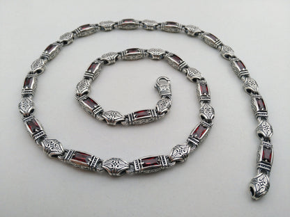 silver necklace with red stones and hand engraving